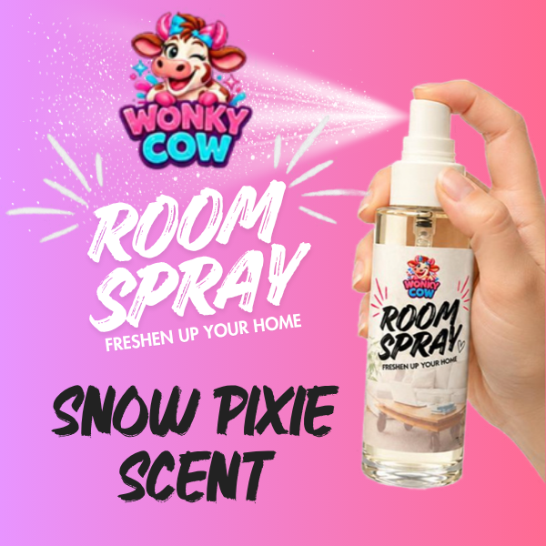 A hand holding a Wonky Cow Room Spray bottle labeled 'Snow Pixie Scent' against a bright pink background with product text and the Wonky Cow logo.