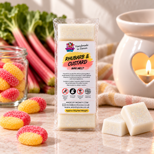 A package of Rhubarb & Custard Wax Melts by Wonyky Cow Devon, displayed on a marble surface with rhubarb stalks, a glass jar of colorful gummy candies, and wax melts in use inside a ceramic holder with a lit candle.